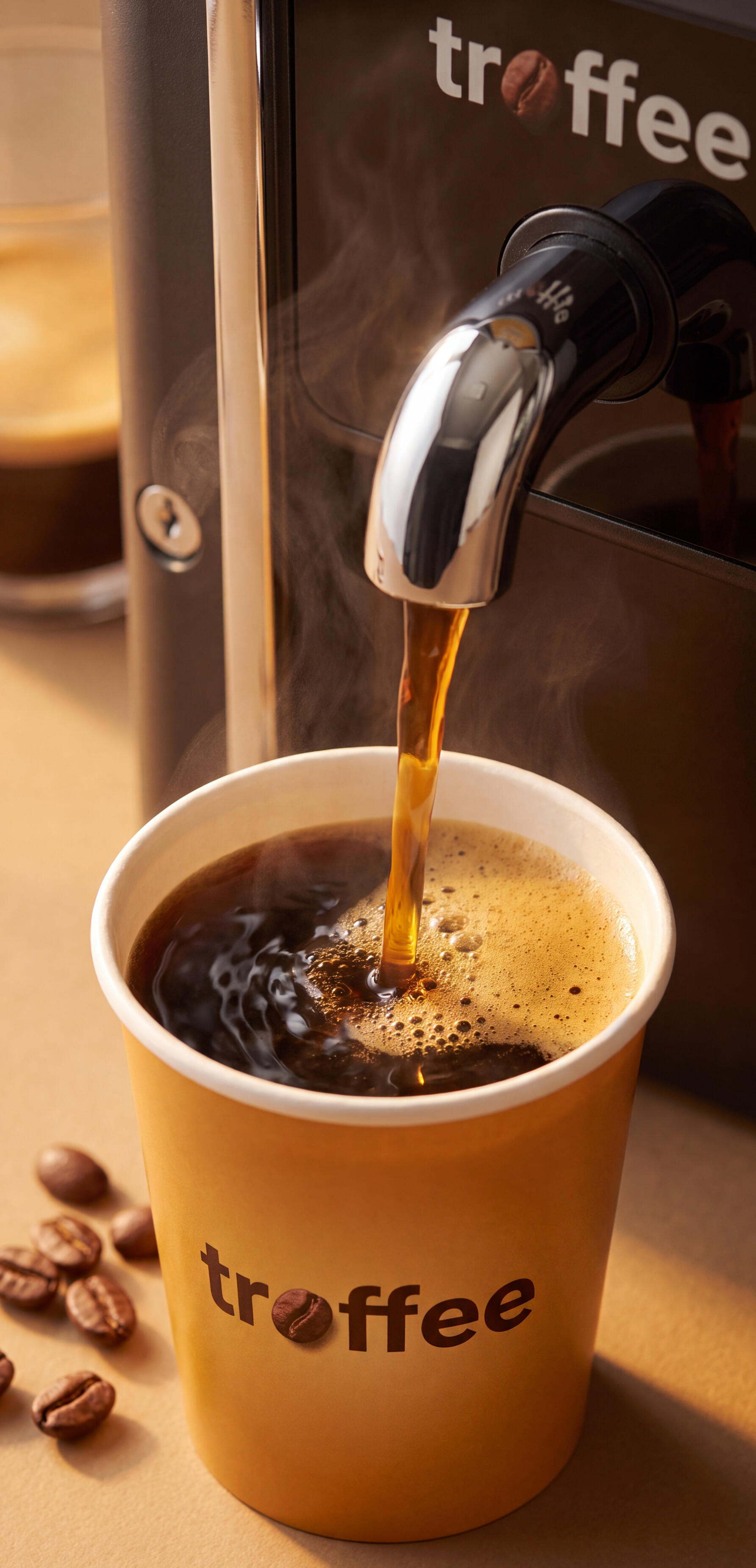 Black coffee pouring into a Troffee cup, fresh from the machine